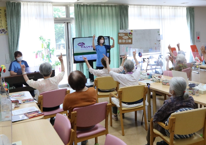 機能訓練指導員の指導の元体操を楽しむ利用者さんたち